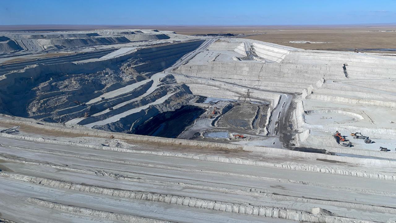The open pit seen end to end, with excavators working the coal at its floor